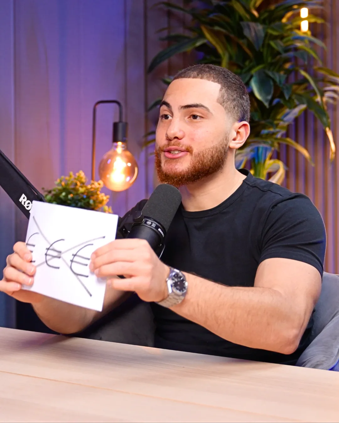 Alan Wöhler hält ein Blatt mit durchgestrichenen Euro-Zeichen hoch